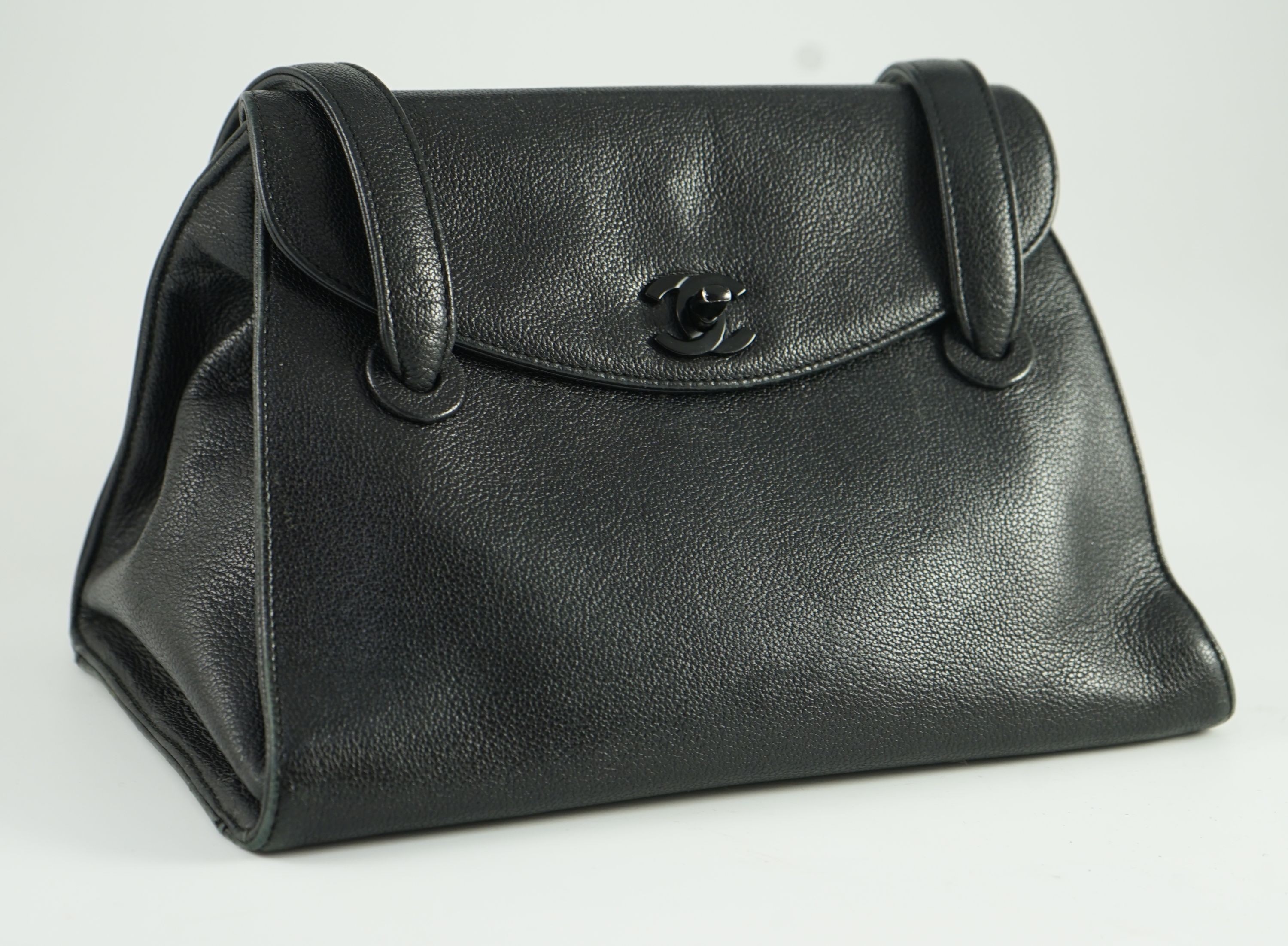 A black Chanel shoulder bag with two straps and Chanel logo lock